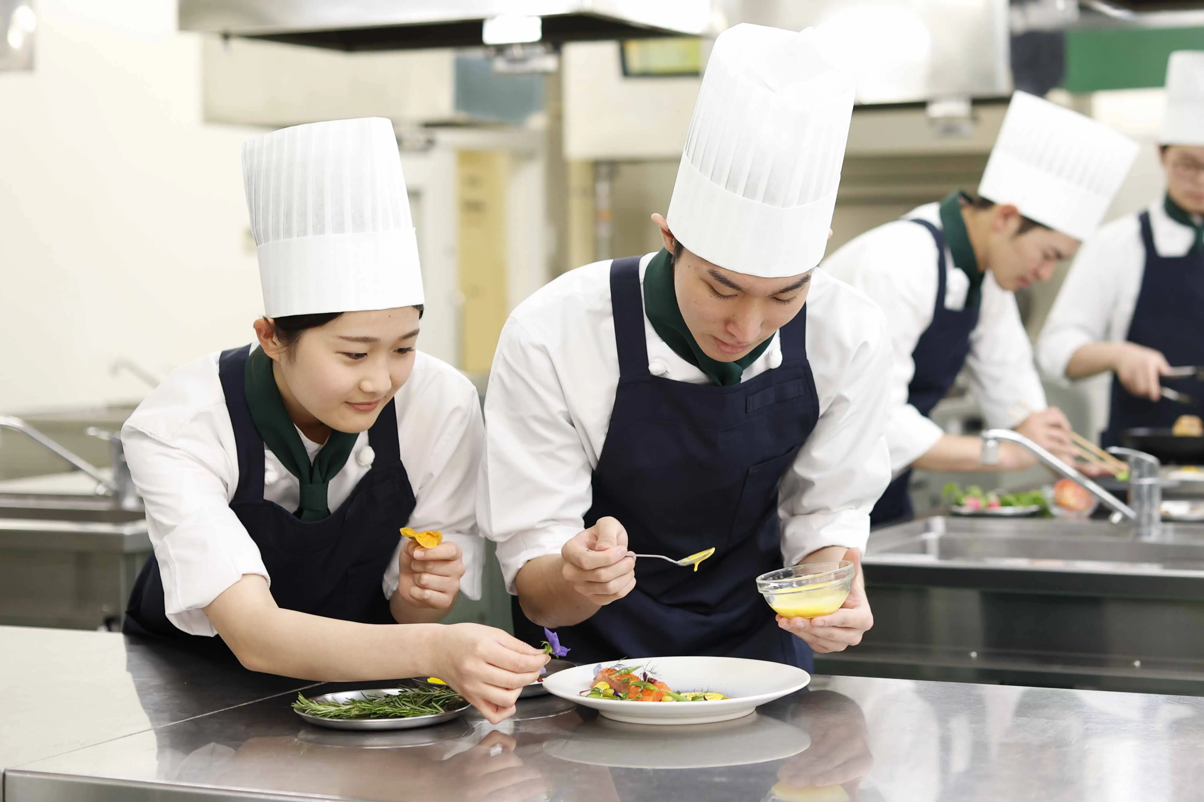 コック帽を被った調理する専門学生の写真