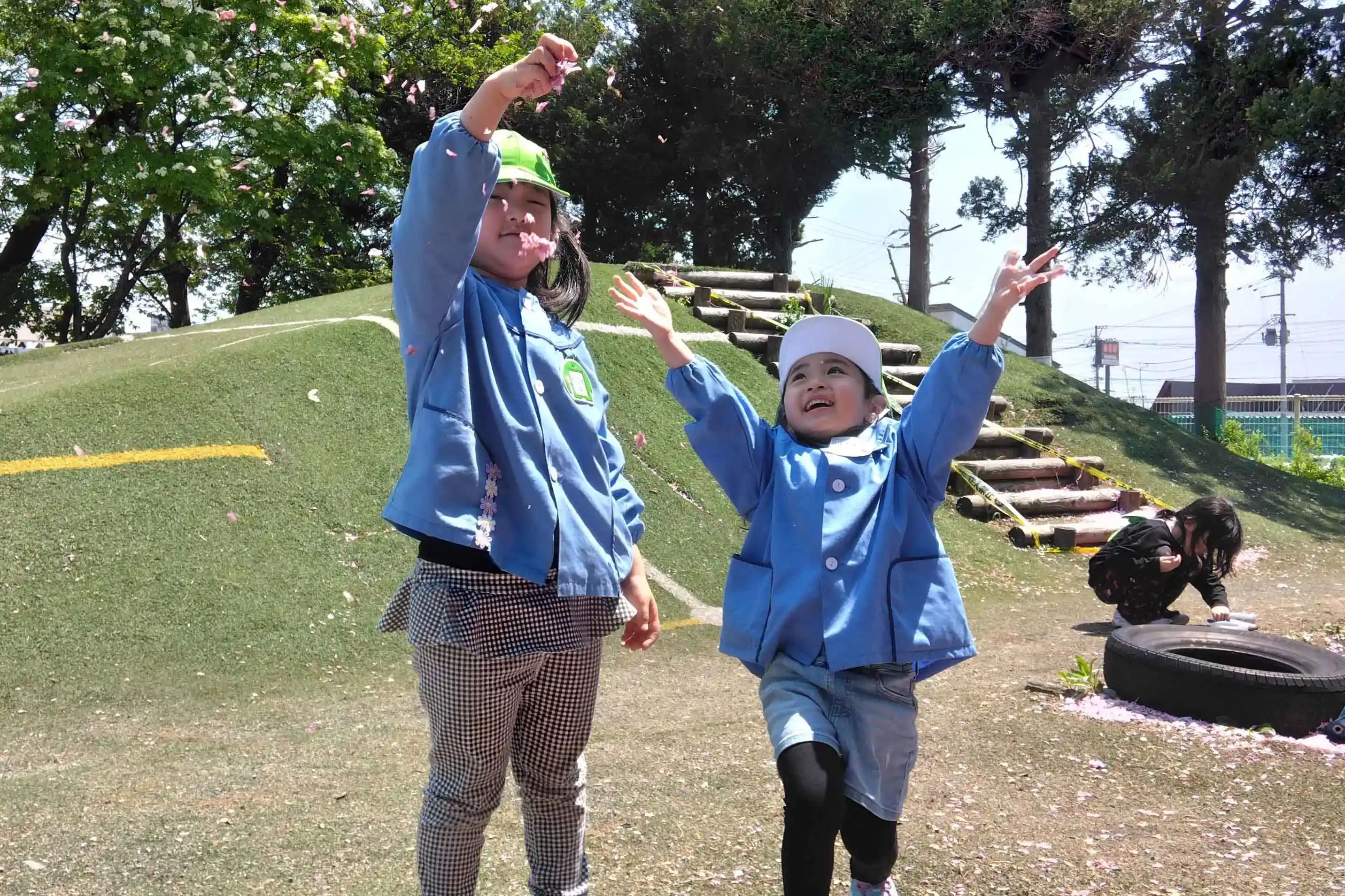 グループページのメイン写真「園児が花びらで遊んでいる様子」