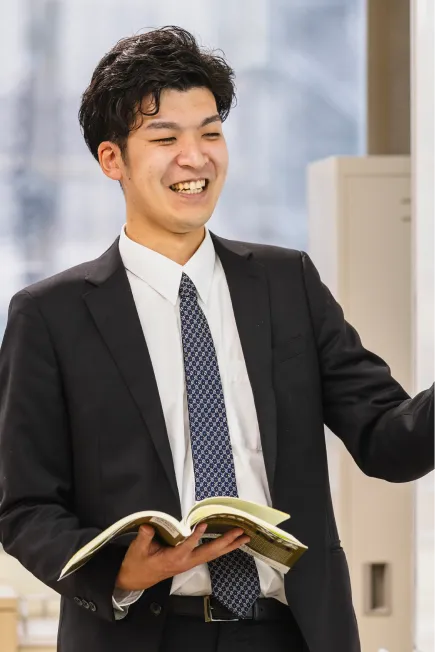 男性教員がホワイトボードで説明する様子の写真