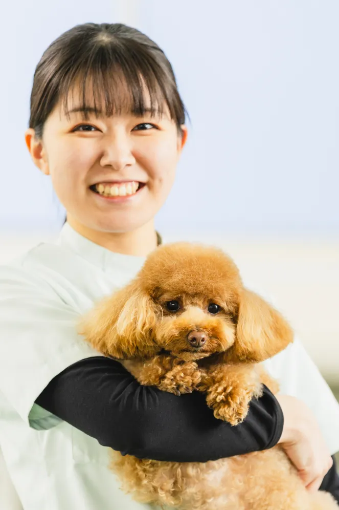 ペットの専門学生が犬を抱っこする写真